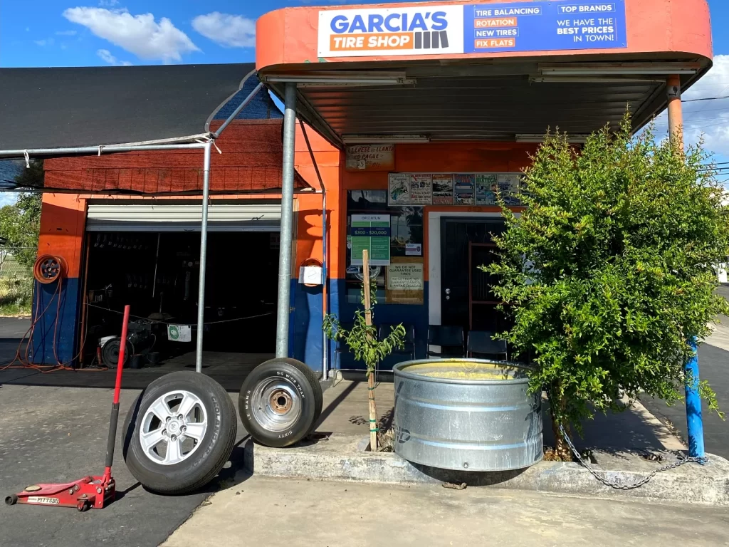 Photograph of Garcia's Tire Shop storefront in Madera, California, with orange and navy signage and tires displayed out front.