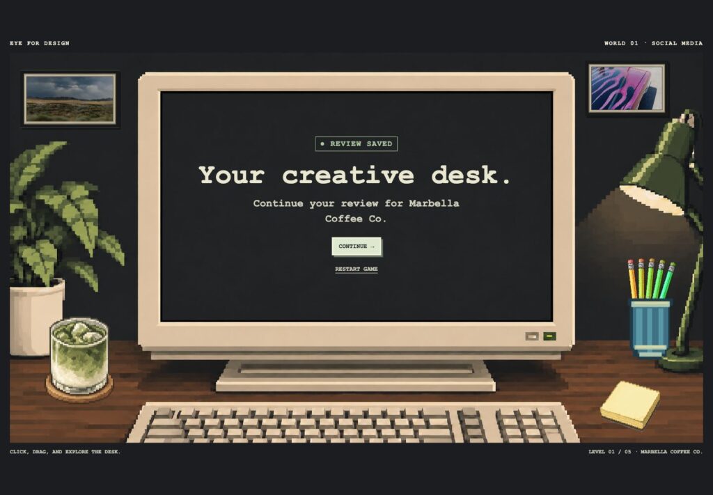 Eye for Design pixel-art desk with a computer, matcha, lamp, pencils and framed photographs.